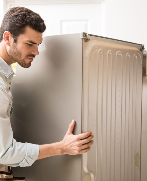 Electrician moving a fridge in a kitchen Our Repair Process – Crafted for Elegance and Accuracy